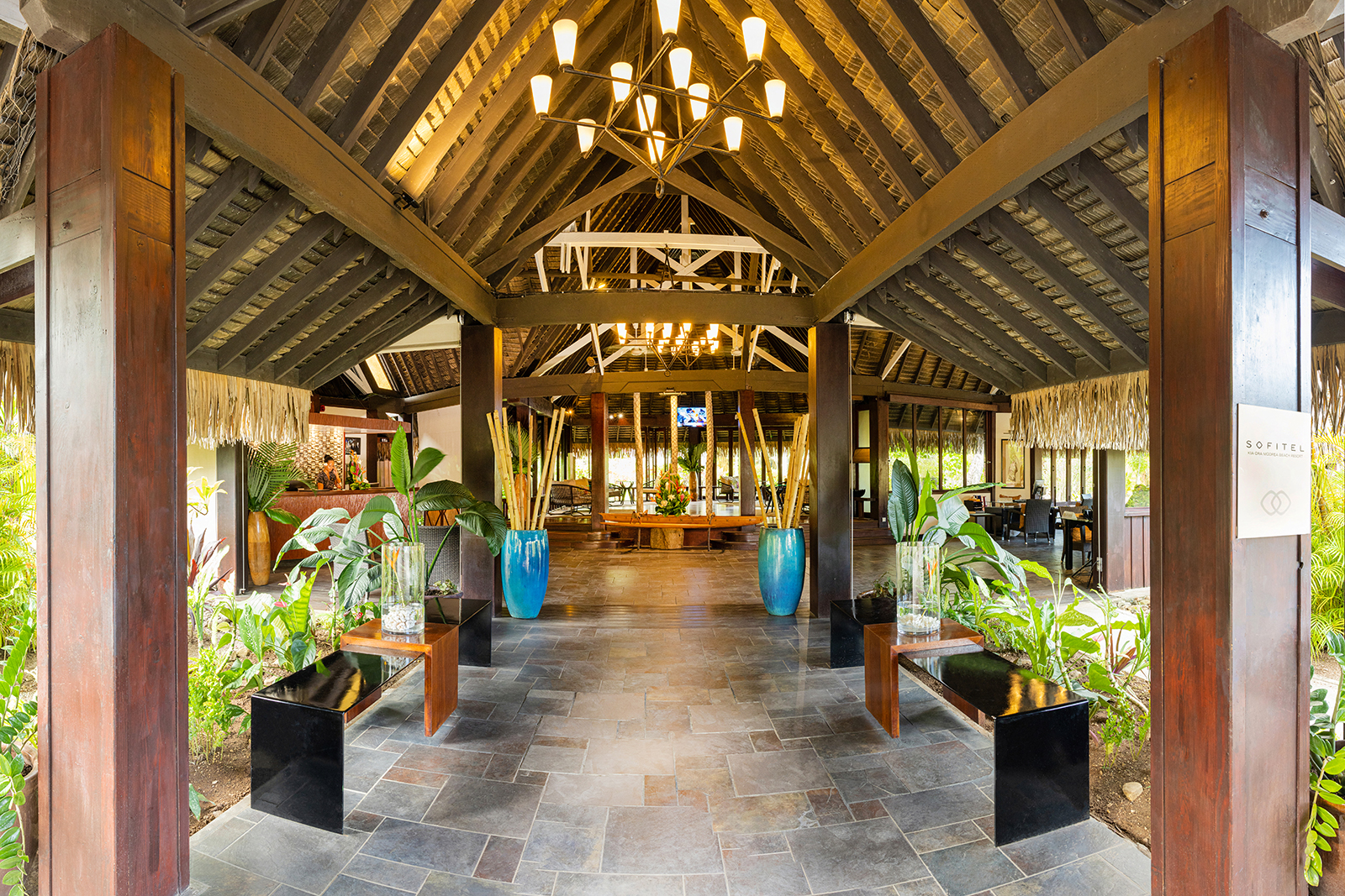 A look into the welcoming reception area filled with verdant greens and a beautiful wooden roof at Sofitel Kia Ora Moorea Beach Resort